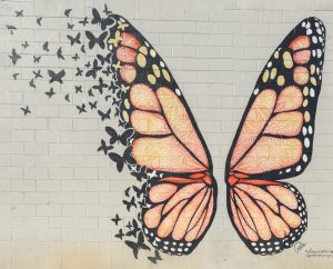Colorful oversized butterfly mural with vibrant wings on a roadside wall in Sevierville, Tennessee, a popular photo spot.