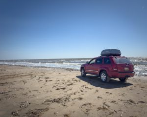 Sandy beach with tire tracks and ocean waves, Sea Rim State Park, Sabine Pass, Texas coastline
